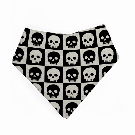 Baby bandana bib with black and white skull pattern on a checkered background