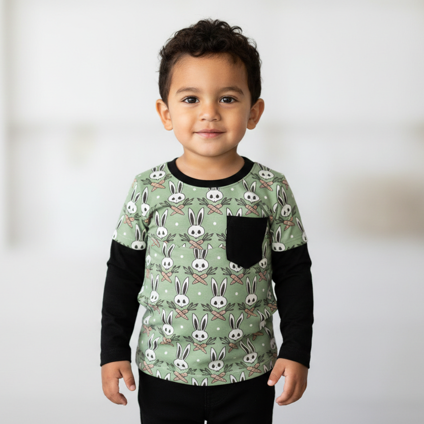Child wearing a green shirt with bunny pattern against a white background