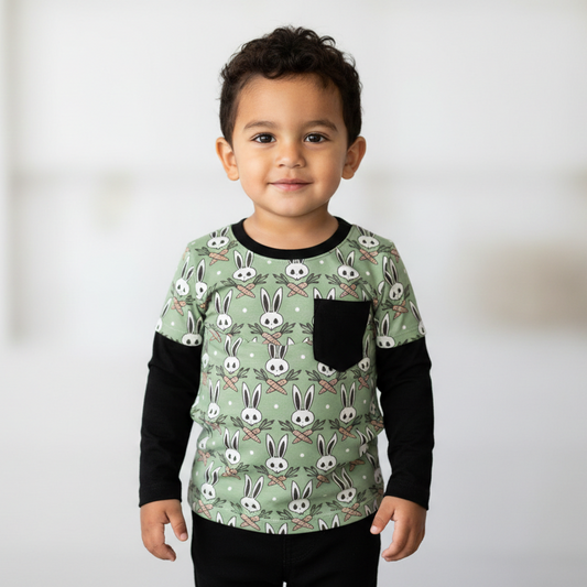 Child wearing a green shirt with bunny pattern against a white background
