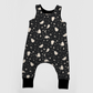 Black baby overalls with white patterns featuring ghosts, stars and moons. 