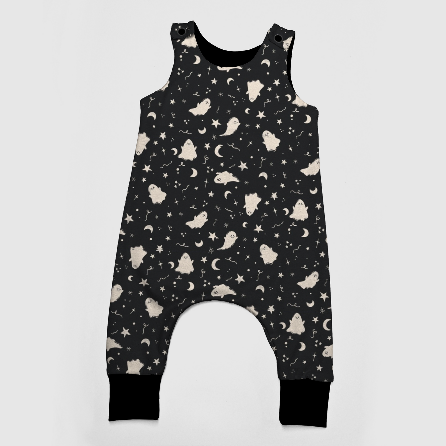 Black baby overalls with white patterns featuring ghosts, stars and moons. 