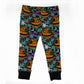 Halloween-themed children's leggings with an all-over print of jack-o'-lanterns, ghosts, bats, and candy on a teal background, finished with black ribbed ankle cuffs.